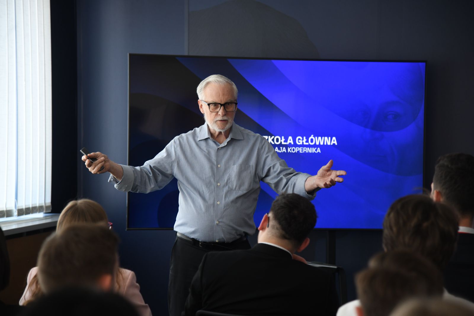 Wykład w Szkole Głównej Mikołaja Kopernika Wykładowca stojący przed studentami podczas wykładu