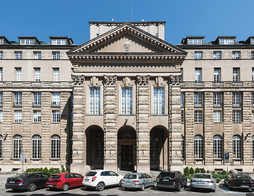 Obrazek dekoracyjny pełniący funkcję przycisku przekierowującego do zakładki z informacjami o kolegiach SGMK. Na zdjęciu zewnętrzna elewacja Banku Rolnego w Warszawie, w którym znajduje się warszawskie kolegium.