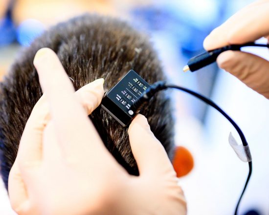 Naukowcy podłączają implant mózgowy do komputera syntezującego głos. (Zdjęcie: Noah Berger)